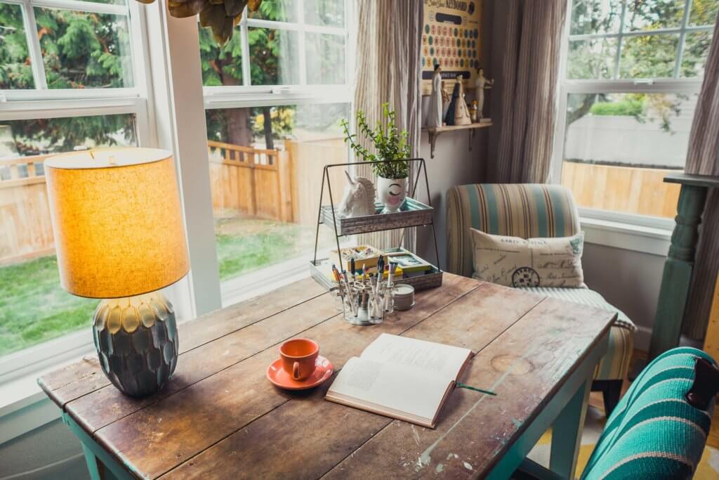 Desk with book open flat and red coffee cup.