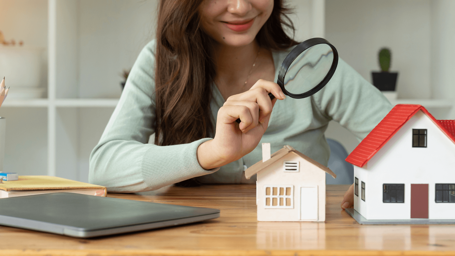 Girl using a magnifier to look at a house