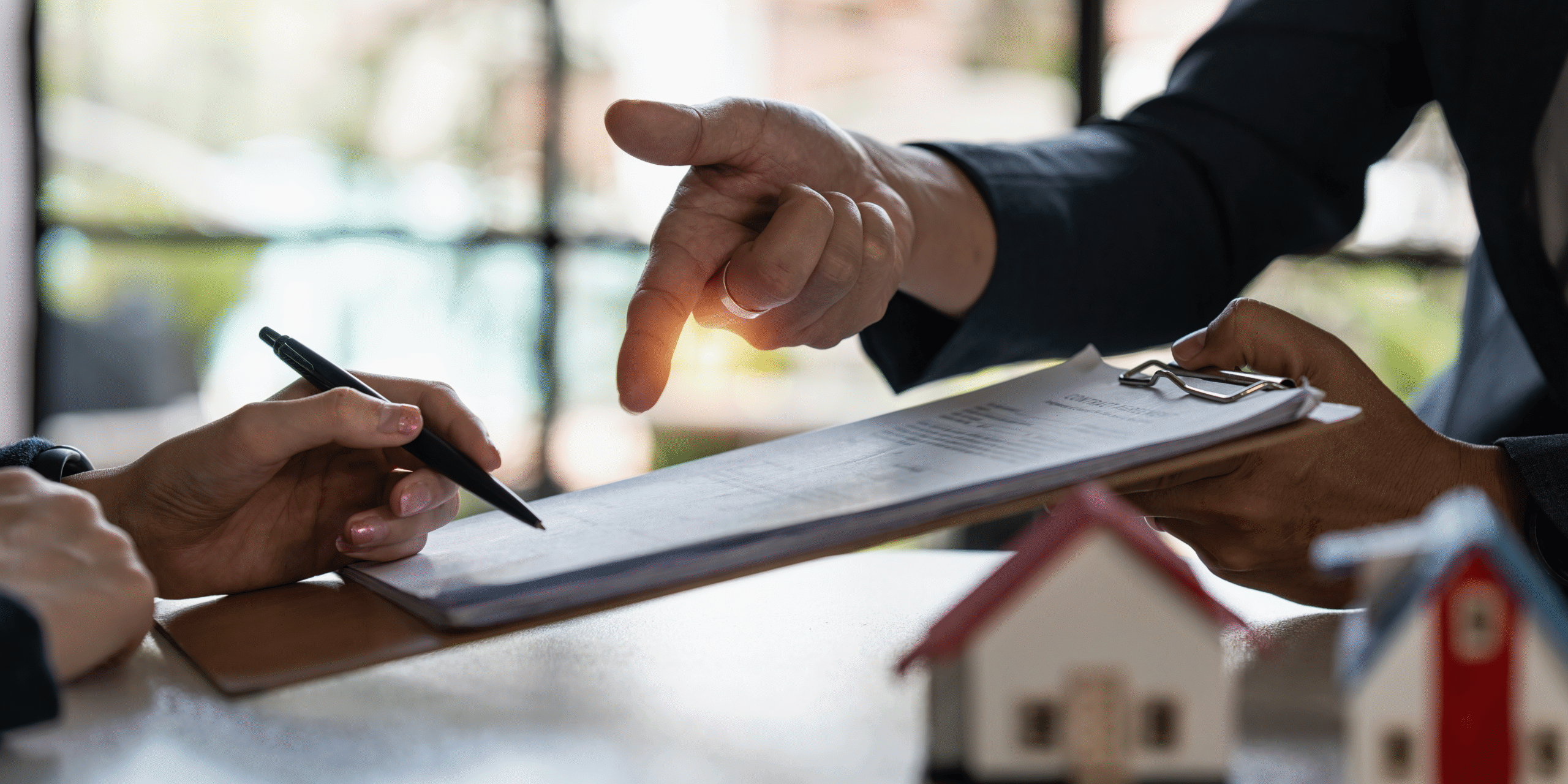 Two people writing and pointing at clipboard. 