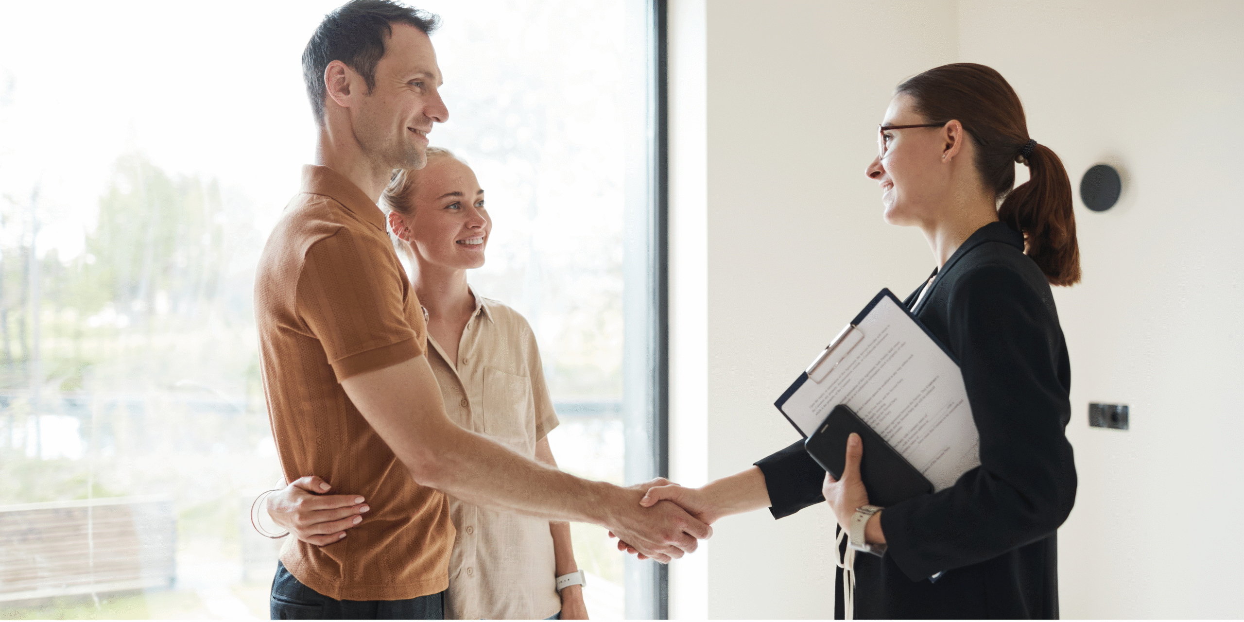 Couple shaking hands with estate agent.