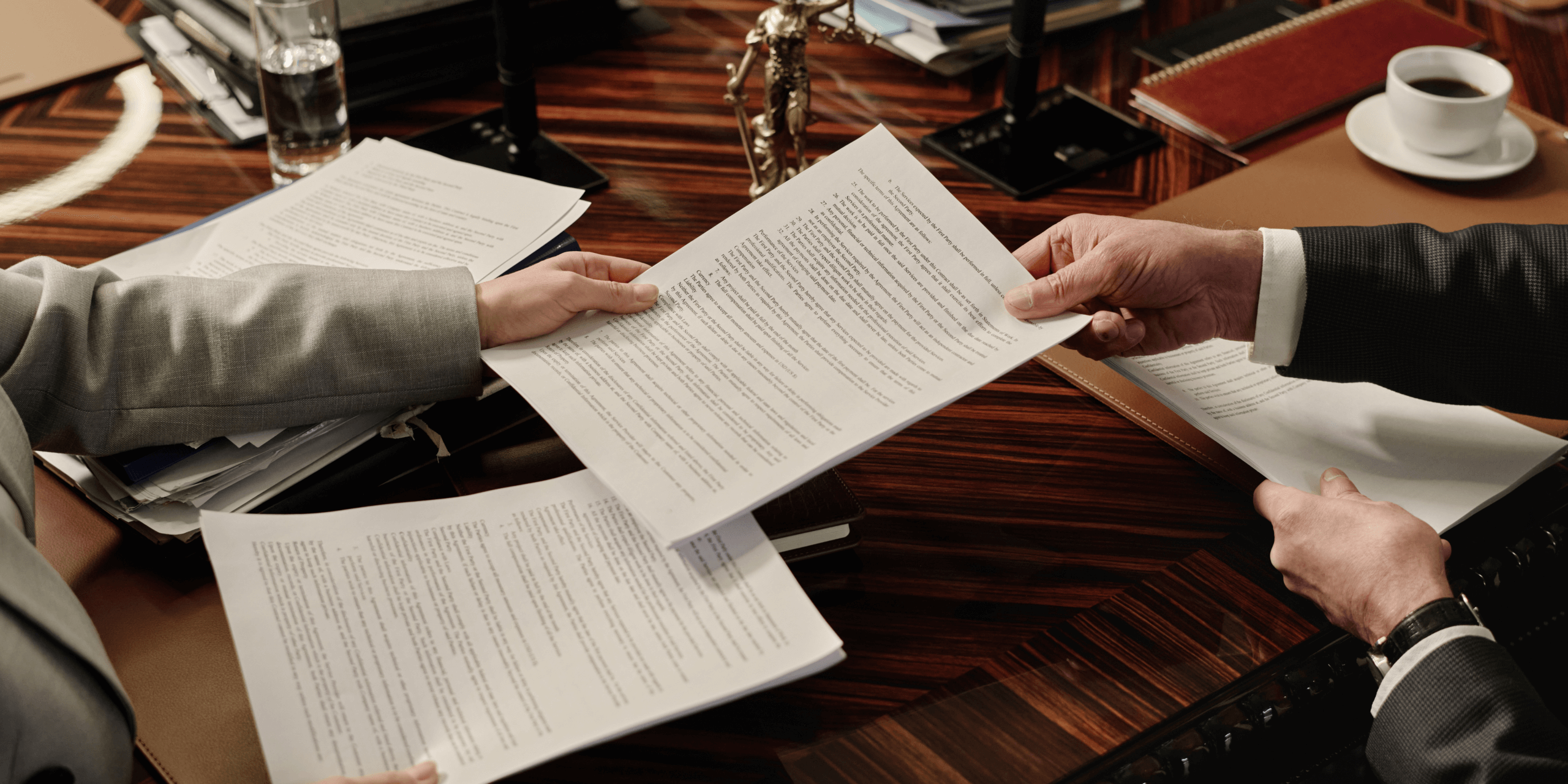 Handing paper documents over table. 