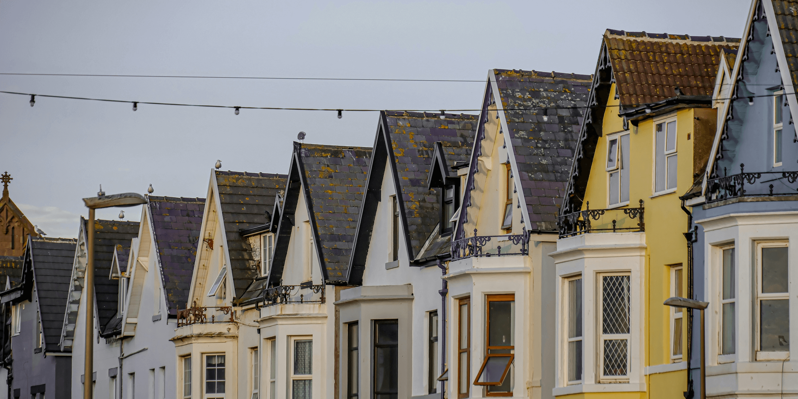 Row of houses with pointed roofs.